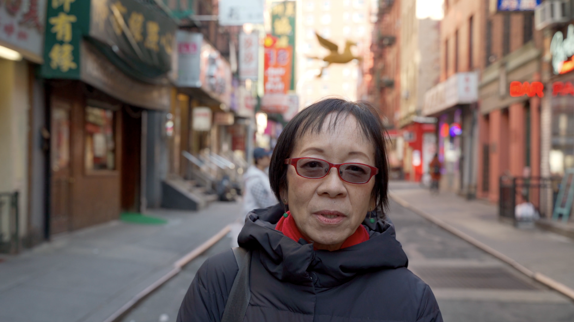 photograph of an asian woman with short hair standing on a Chinatown street